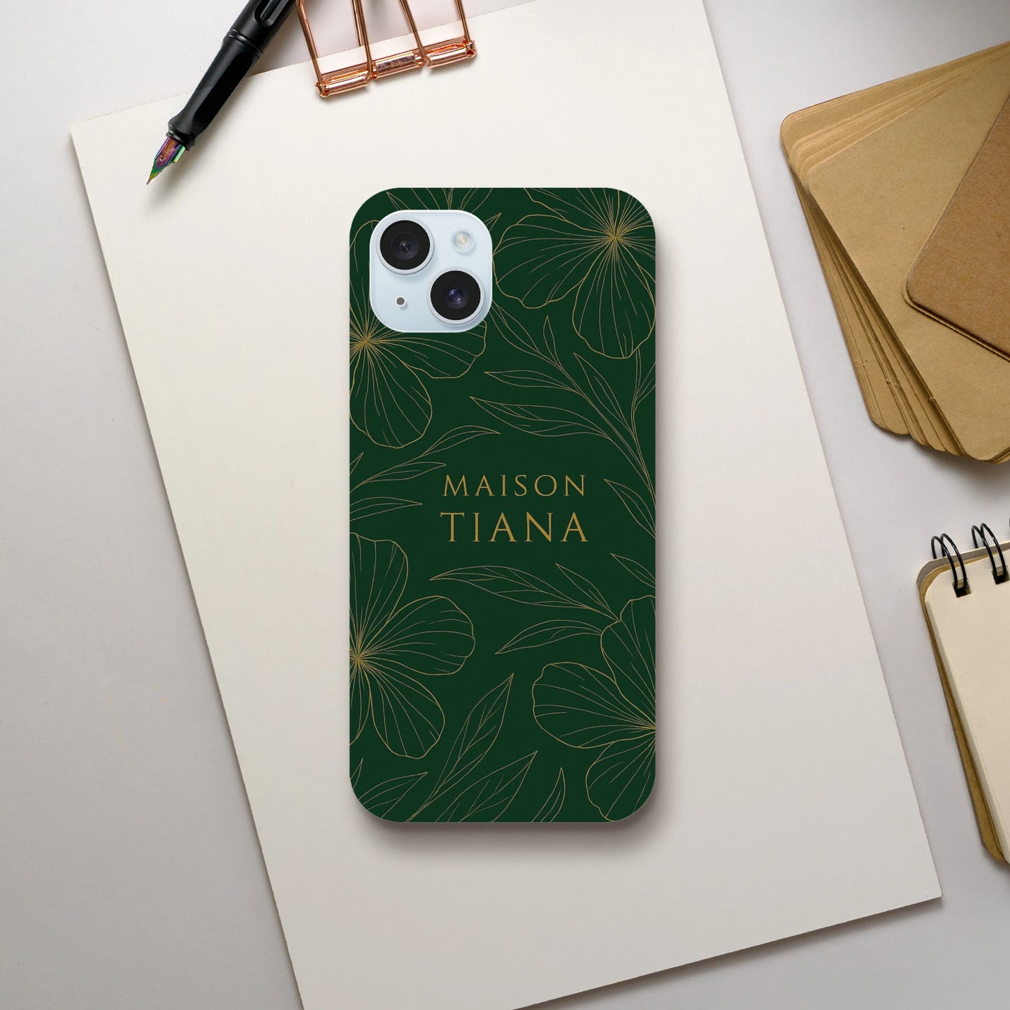 Coque iPhone artistique Maison Tiana posée sur une table – élégance discrète du quotidien.